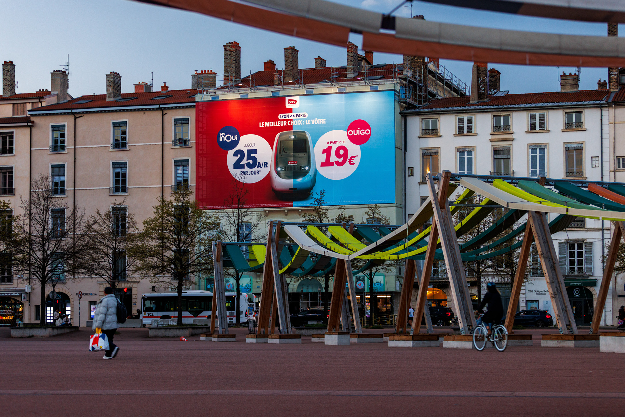 Toile publicitaire sur échafaudage de 180 m² pour la SNCF, vue de face illuminée de nuit au cœur de Lyon.