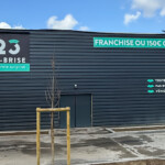 Déploiement multi-sites : façade arrière secondaire à Tourville avec lettrages découpés à la forme et panneaux d'enseigne 123 Pare-Brise.