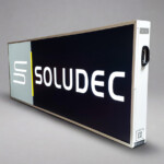 LightBox grue latérale simple face, poignée de transport, logo SOLUDEC, ombre au sol, fond gris.