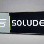 LightBox grue latérale 286×100 LightAir, logo SOLUDEC rétroéclairé, fond gris studio, visibilité chantier.