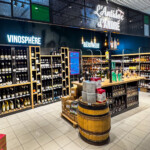 Vue de la bierothèque et vinosphère avec lettrages en bloc LED lumineux blancs à Saint Bonnet de Mure, marquant le déploiement d'enseignes multi-sites des Boucheries André.