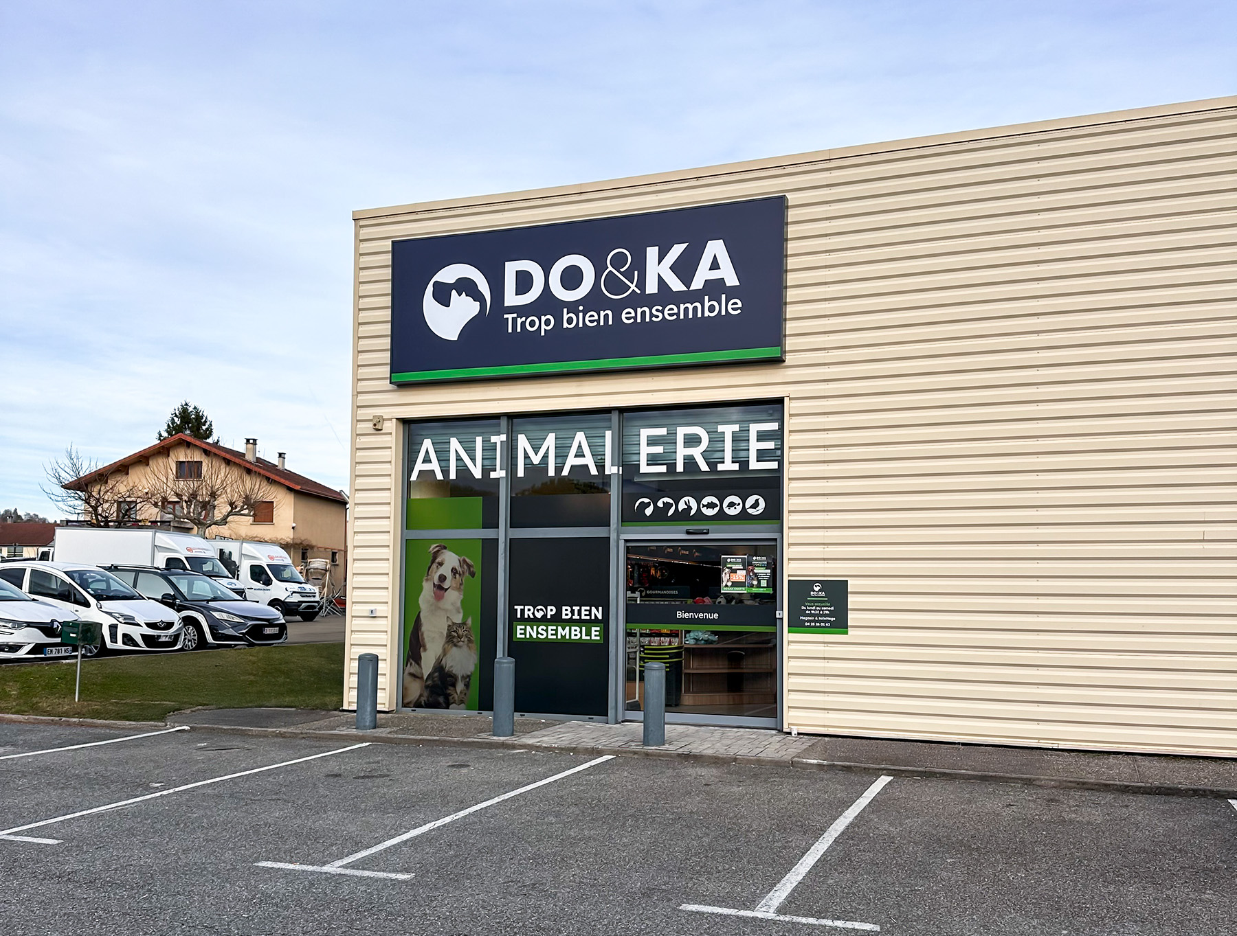 Vue globale de loin de l'enseigne LightBox, de la vitrophanie et du panneau extérieur du magasin DO&KA à Chatte.