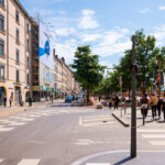Prise de vue lointaine de côté en journée de la bâche publicitaire finançant les travaux de façade place Bellecour.