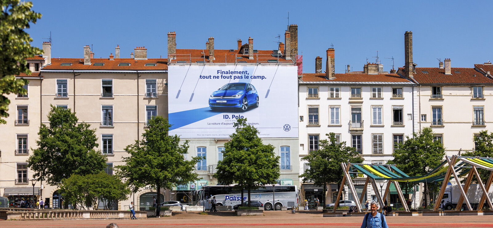 Vue lointaine de jour montrant l'intégration urbaine parfaite pour financer des travaux de façade à Lyon, place Bellecour.
