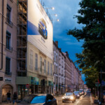 Toile sur échafaudage mise en valeur par ses spots de nuit pour financer les travaux de façade place Bellecour à Lyon.