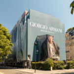 Vue d'angle de l'habillage de bâtiment monumental Giorgio Armani drapant les façades de l'immeuble sur l'avenue Montaigne à Paris.