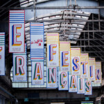 Ambiance immersive avec notre affichage événementiel sur mesure à Lyon : une grande toile suspendue habillant l'espace Le Festin Français.