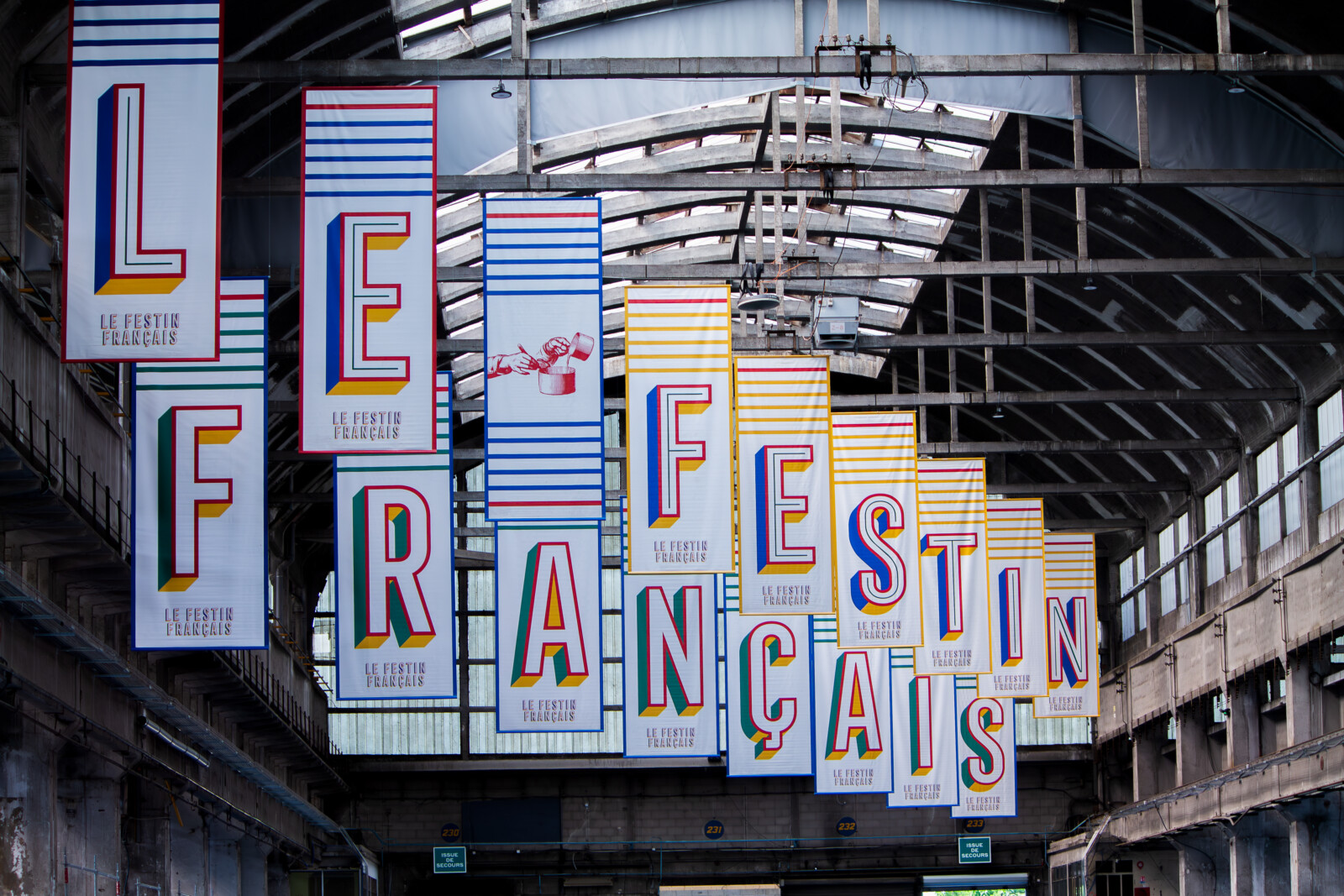 Ambiance immersive avec notre affichage événementiel sur mesure à Lyon : une grande toile suspendue habillant l'espace Le Festin Français.