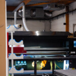 Imprimante industrielle grand format en cours d'impression des visuels Fondation HCL dans l'atelier.