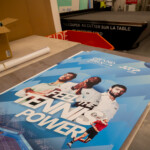 Impression d'un visuel grand format "Feel the Tennis Power" sur table de découpe pour la signalétique événementielle à Lyon.