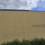 Façade en bardage d'un bâtiment sur un site industriel avant l'installation d'une toile tendue grand format.